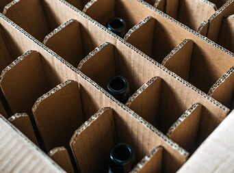 Corrugated cardboard beer bottle packaging with dividers. Sustainable packaging, beverage transport, beer shipping protection, eco-friendly material solutions.